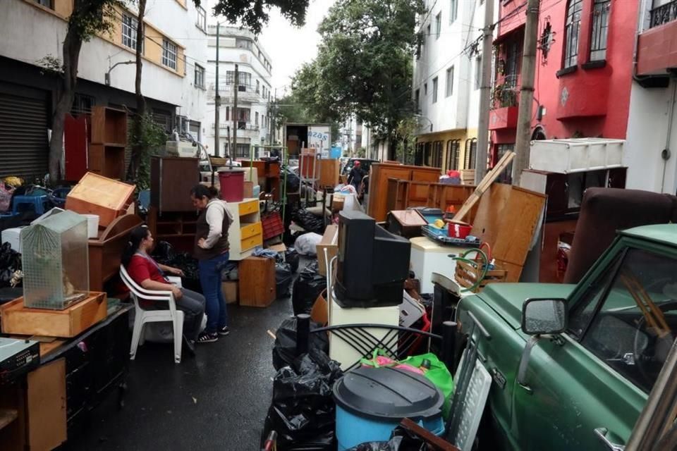 Muebles y pertenencias ocupan una calle frente a varios inmuebles en la Ciudad de México. 

