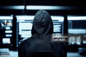 Persona frente a una computadora en un entorno digital, representando un posible riesgo para la seguridad de datos.